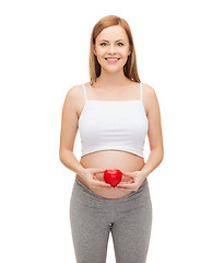 Image showing happy future mother holding small red heart