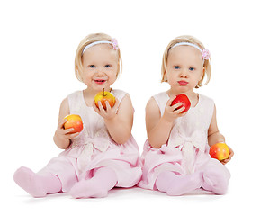 Image showing two identical twin girls playing with apples