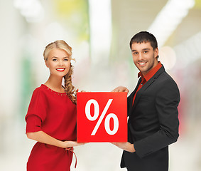 Image showing smiling man and woman with percent sign