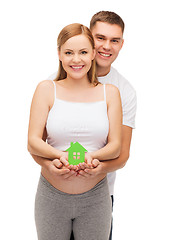 Image showing happy young family expecting child with house