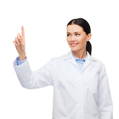 Image showing smiling female doctor pointing to something