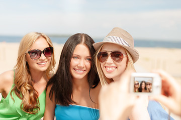 Image showing girls taking photo with digital camera in cafe