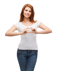 Image showing smiling girl showing heart with hands