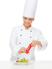 Image showing smiling female chef with preparing salad