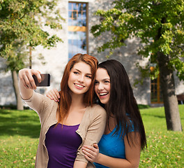 Image showing two smiling teenagers with smartphone