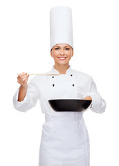 Image showing smiling female chef with pan and spoon