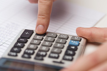 Image showing close up of businessman with papers and calculator