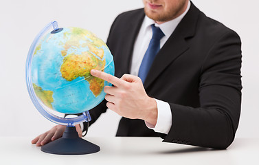 Image showing businessman pointing finger to earth globe