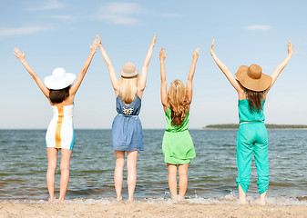 Image showing girls with hands up on the beach