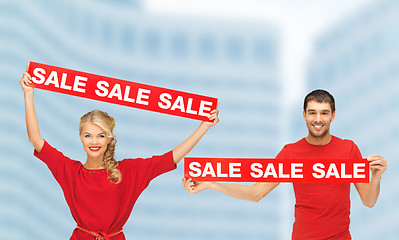 Image showing woman and man with red sale signs