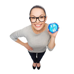 Image showing smiling woman in eyeglasses with blue clock