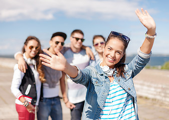 Image showing teenage girl with headphones and friends outside