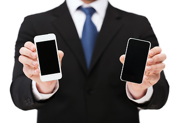 Image showing businessman showing smartphones with blank screens