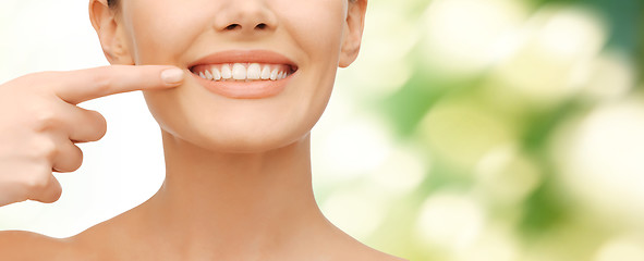 Image showing beautiful woman pointing to teeth