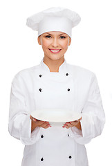 Image showing smiling female chef with empty plate