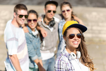 Image showing teenage girl with headphones and friends outside