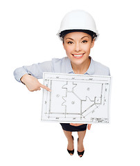 Image showing businesswoman in helmet showing with blueprint