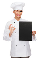 Image showing smiling female chef with black blank paper