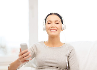 Image showing woman with smartphone and headphones at home