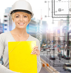 Image showing female contractor in helmet with folder