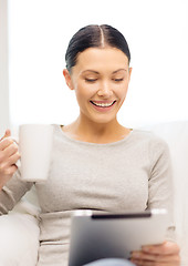 Image showing smiling woman with tablet pc computer and cup