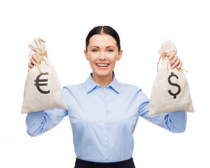 Image showing businesswoman holding bags with dollar and euro