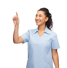 Image showing smiling doctor or nurse pointing to something