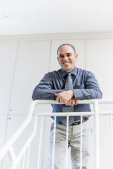 Image showing Businessman standing in office hallway smiling