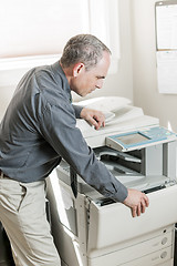 Image showing Man opening photocopier in office