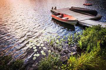 Image showing Rowboat at lake shore at sunrise