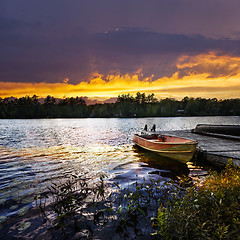 Image showing Boat docked on lake at sunset