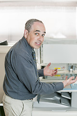 Image showing Man frustrated with photocopier