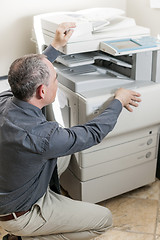 Image showing Man opening photocopier in office