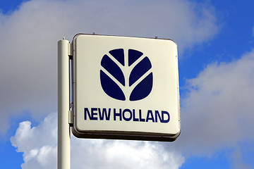 Image showing New Holland Sign against Blue Sky with Some Clouds