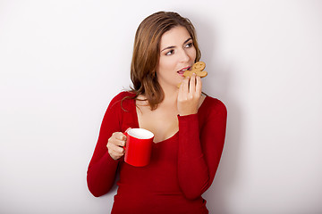 Image showing Woman drinking coffee with cookies