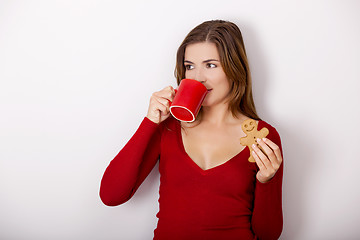 Image showing Woman drinking coffee with cookies