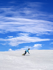 Image showing Snowboarder on ski slope and blue sky with clouds