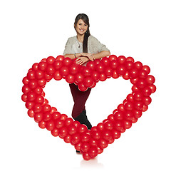 Image showing Smiling woman holding red balloon heart