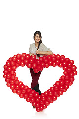 Image showing Smiling woman holding red balloon heart