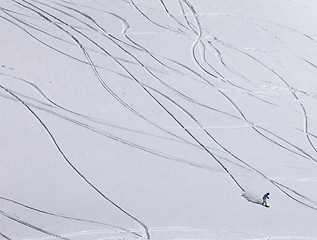 Image showing Snowboarder downhill on off piste slope with newly-fallen snow