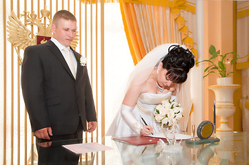 Image showing Pretty pair signing document of marriage