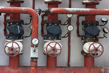 Image showing Red pipes with valves and manometers