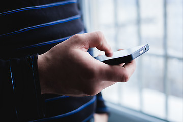 Image showing The man is using a smartphone. Modern mobile phone in hand.