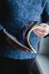 Image showing A man looks at a magazine. Press hands.