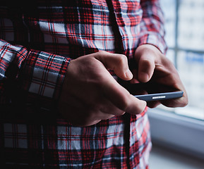 Image showing The man is using a smartphone. Modern mobile phone in hand.