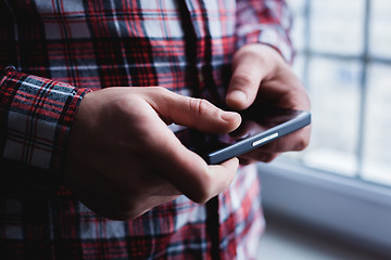 Image showing The man is using a smartphone. Modern mobile phone in hand.