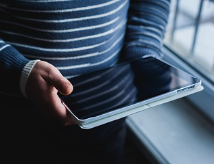 Image showing The man uses a tablet PC. Modern gadget in hand.