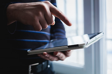 Image showing The man uses a tablet PC. Modern gadget in hand.