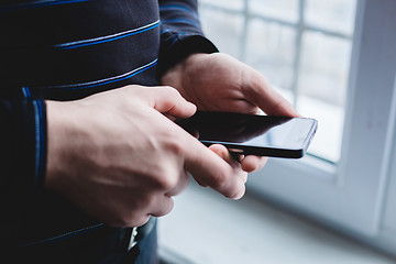 Image showing The man is using a smartphone. Modern mobile phone in hand.