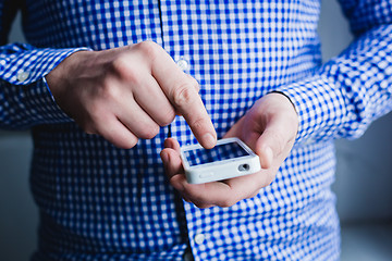 Image showing The man is using a smartphone. Modern mobile phone in hand.